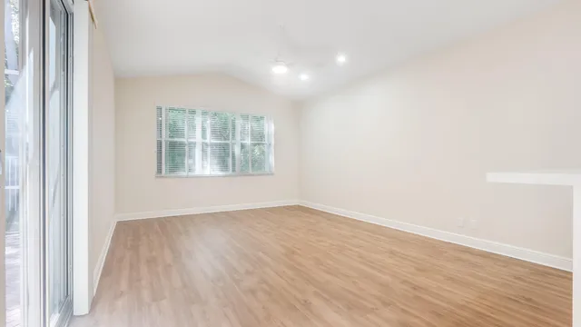 an empty room with wooden floor and windows
