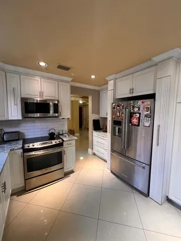 a kitchen with stainless steel appliances kitchen island granite countertop a sink and cabinets