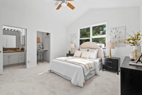 a bedroom with a bed a mirror and lamp