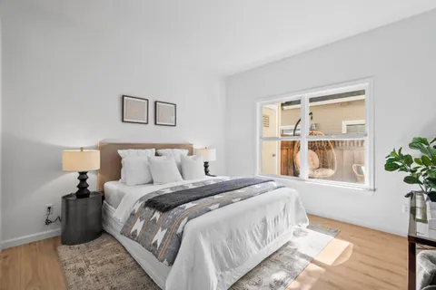 a bedroom with a bed table and a window