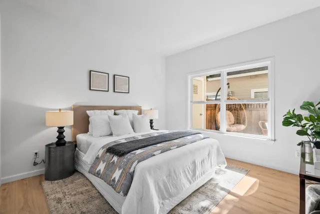 a bedroom with a bed table and a window