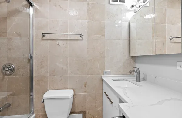 a bathroom with a sink a toilet and shower