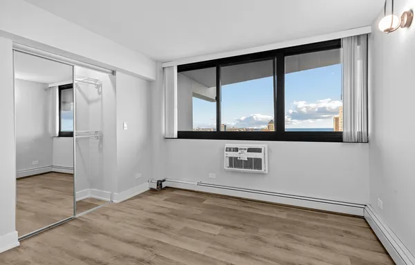 an empty room with wooden floor and a window