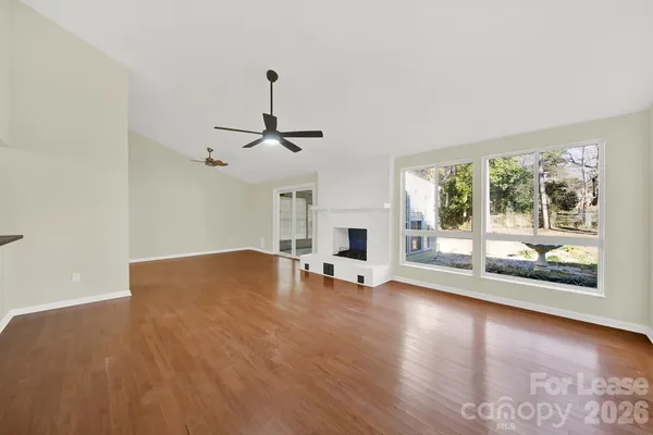a view of empty room with wooden floor and fireplace