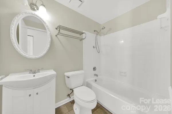 a white toilet sitting next to a bathroom sink and a tub