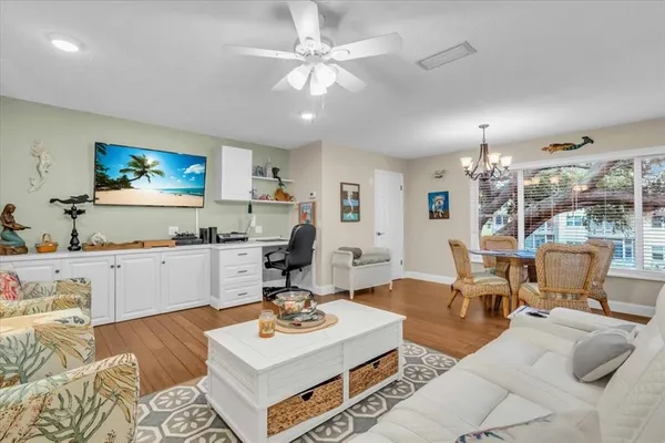 a living room with furniture kitchen view and a large window