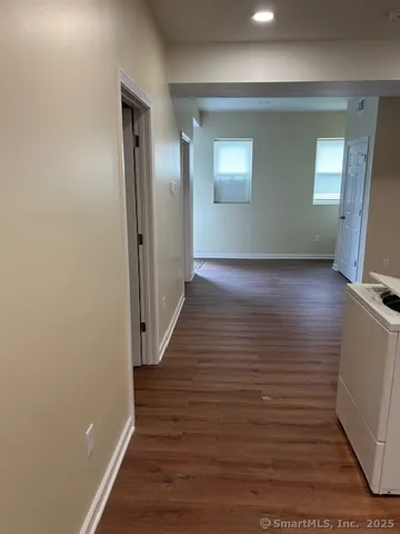 a view of a hallway with wooden floor and staircase