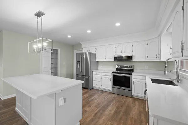 an empty room with wooden floor fireplace and windows