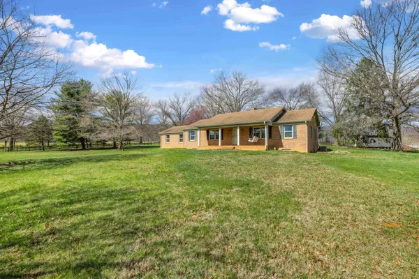 a view of an empty room with chandelier and wooden floor