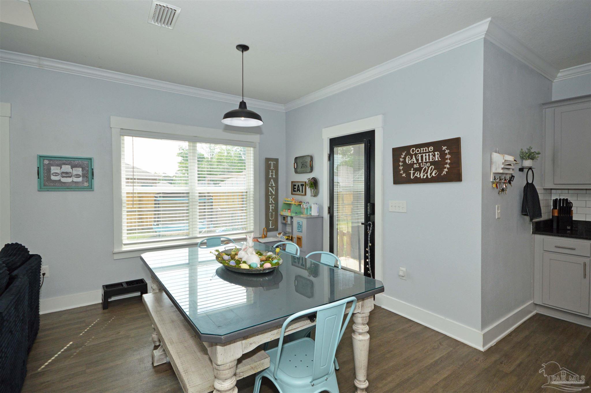 4453 Jude Way Pace, FL 32571 - Photo 12 of 41 a view of a dining room with furniture window and wooden floor