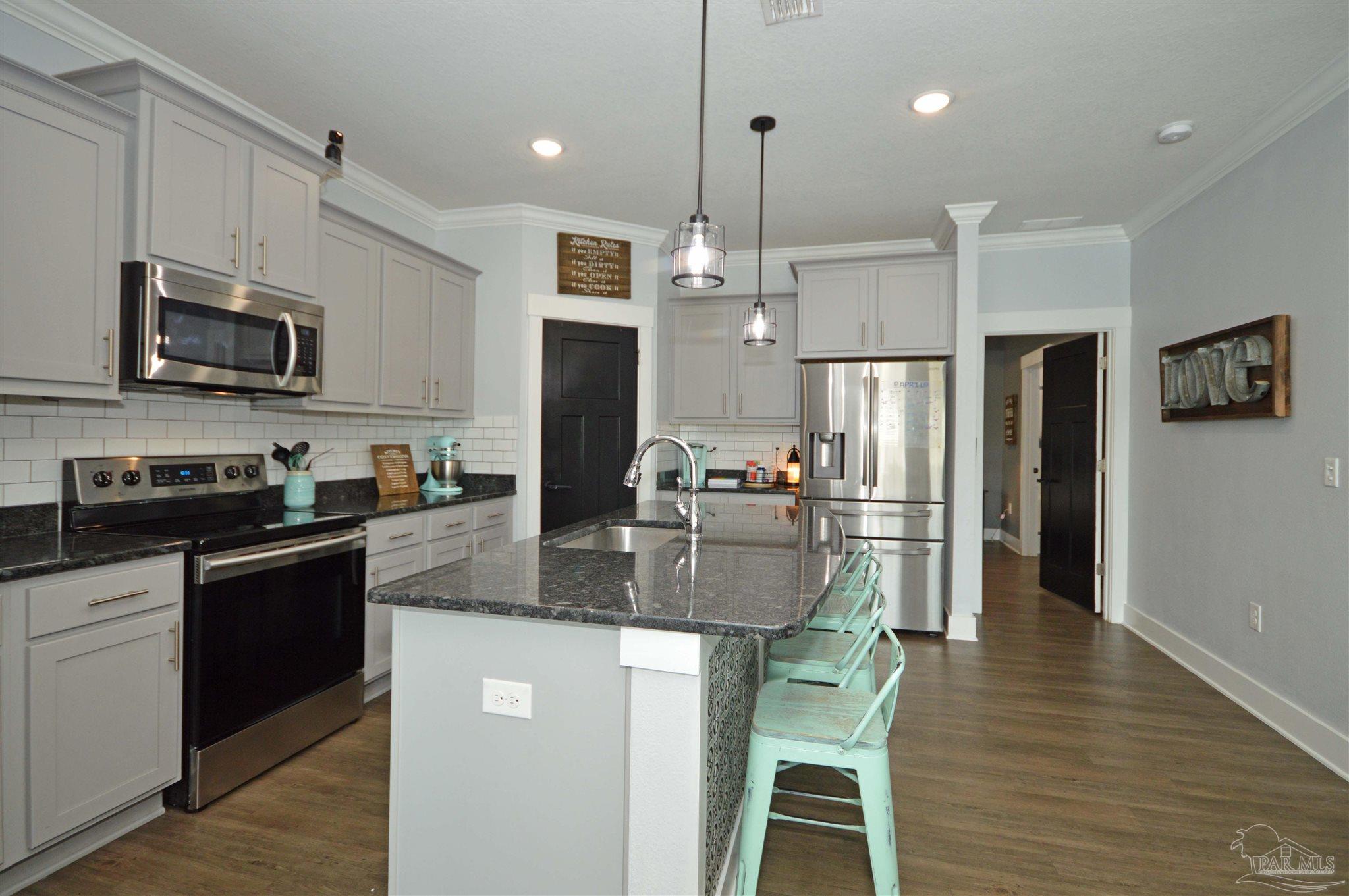 4453 Jude Way Pace, FL 32571 - Photo 16 of 41 a kitchen with stainless steel appliances granite countertop a sink refrigerator and microwave