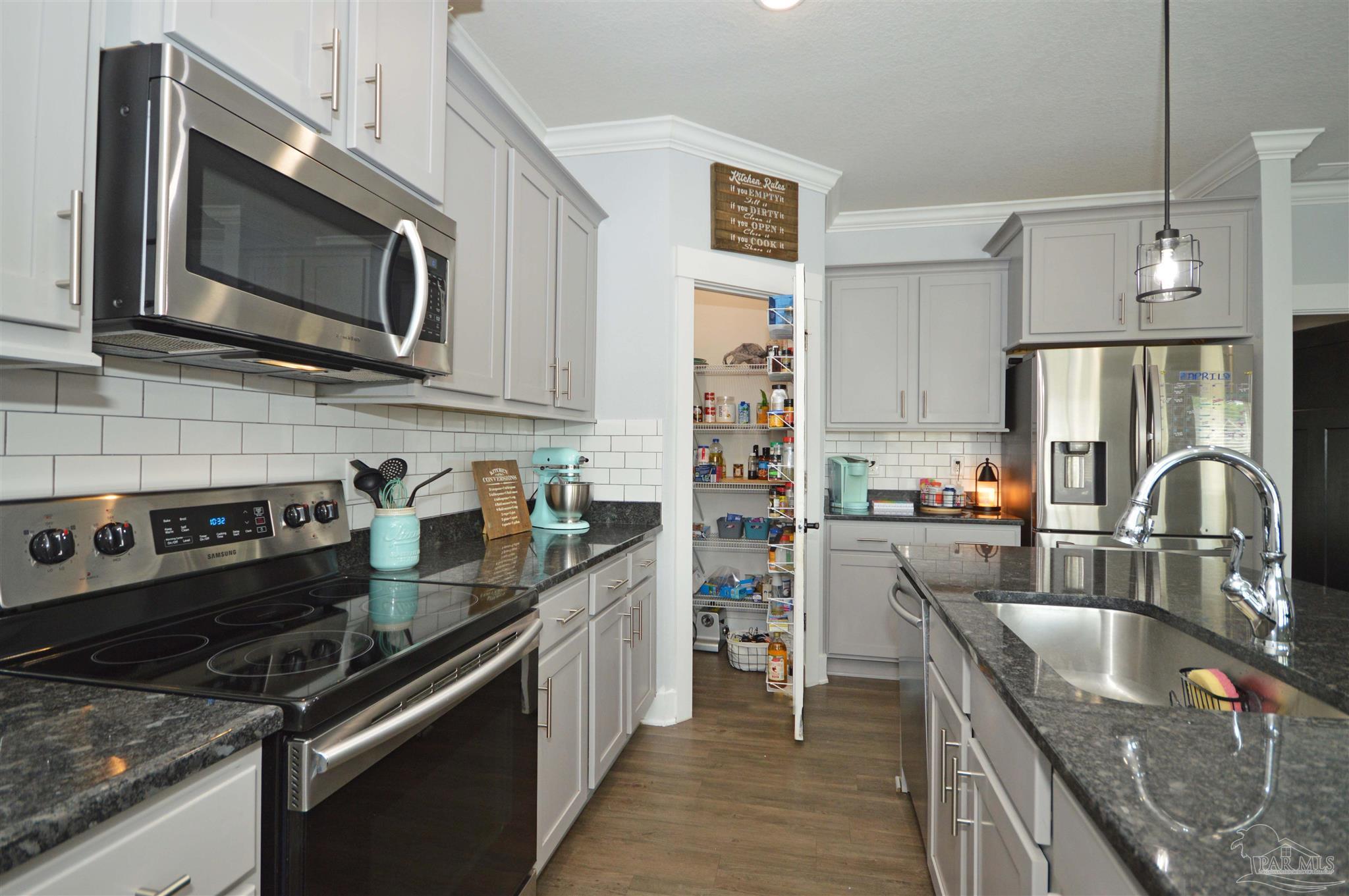 4453 Jude Way Pace, FL 32571 - Photo 20 of 41 a kitchen with stainless steel appliances granite countertop a sink stove and refrigerator