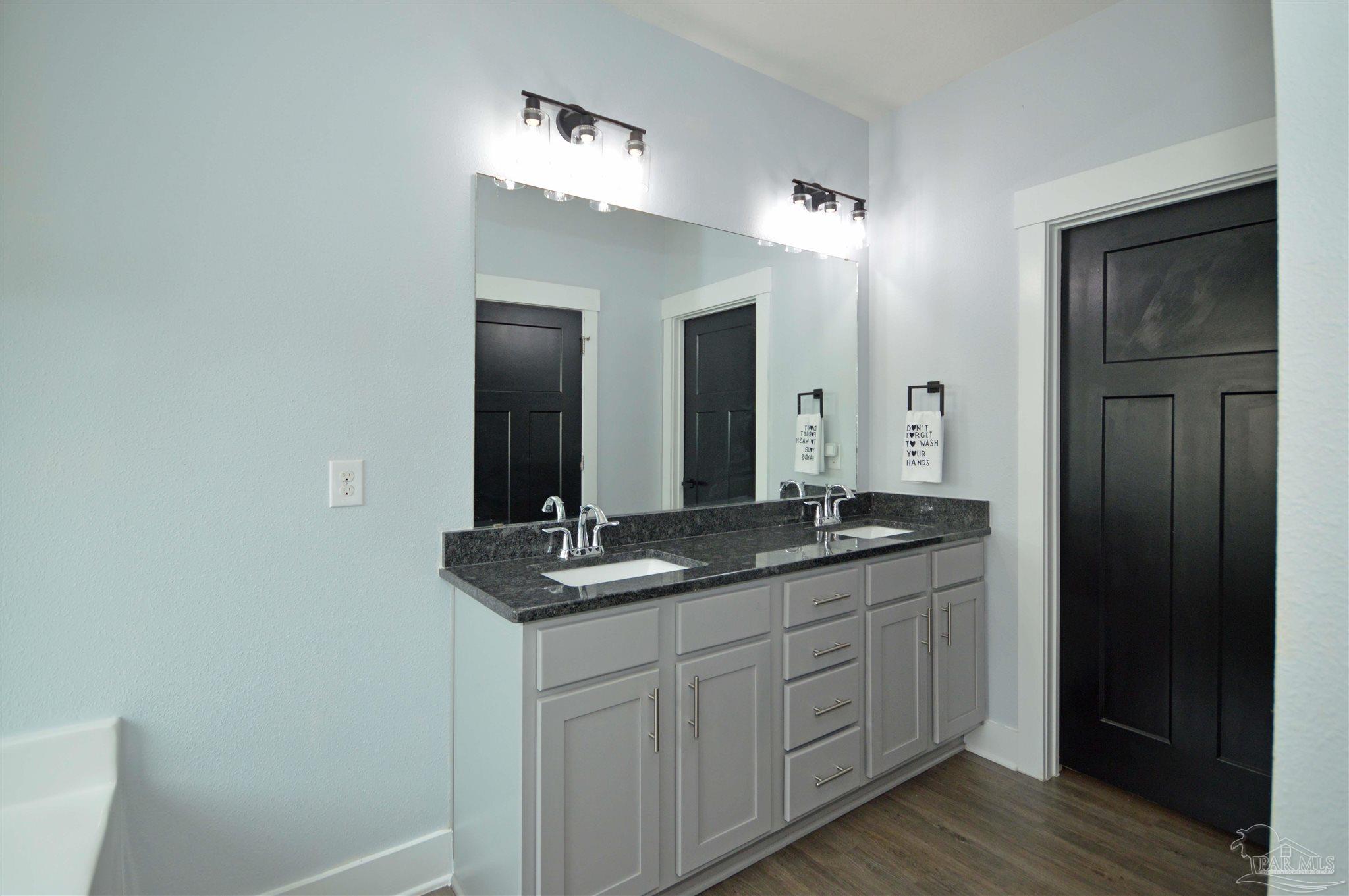 4453 Jude Way Pace, FL 32571 - Photo 23 of 41 a bathroom with a granite countertop sink and a mirror