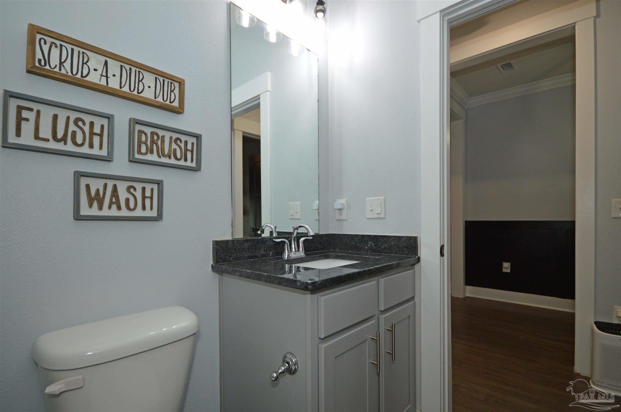 4453 Jude Way Pace, FL 32571 - Photo 24 of 41 a bathroom with a granite countertop sink and a toilet