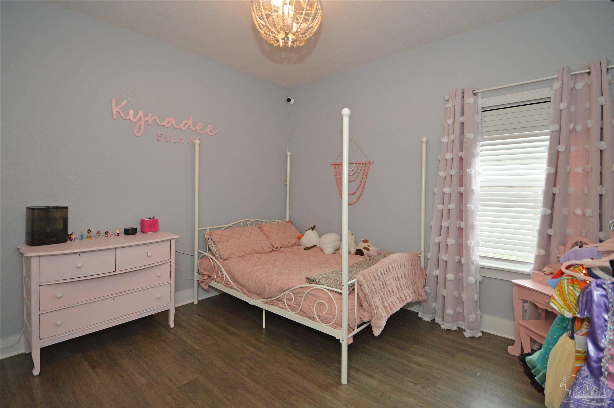 4453 Jude Way Pace, FL 32571 - Photo 32 of 41 a bedroom with a bed and a chandelier