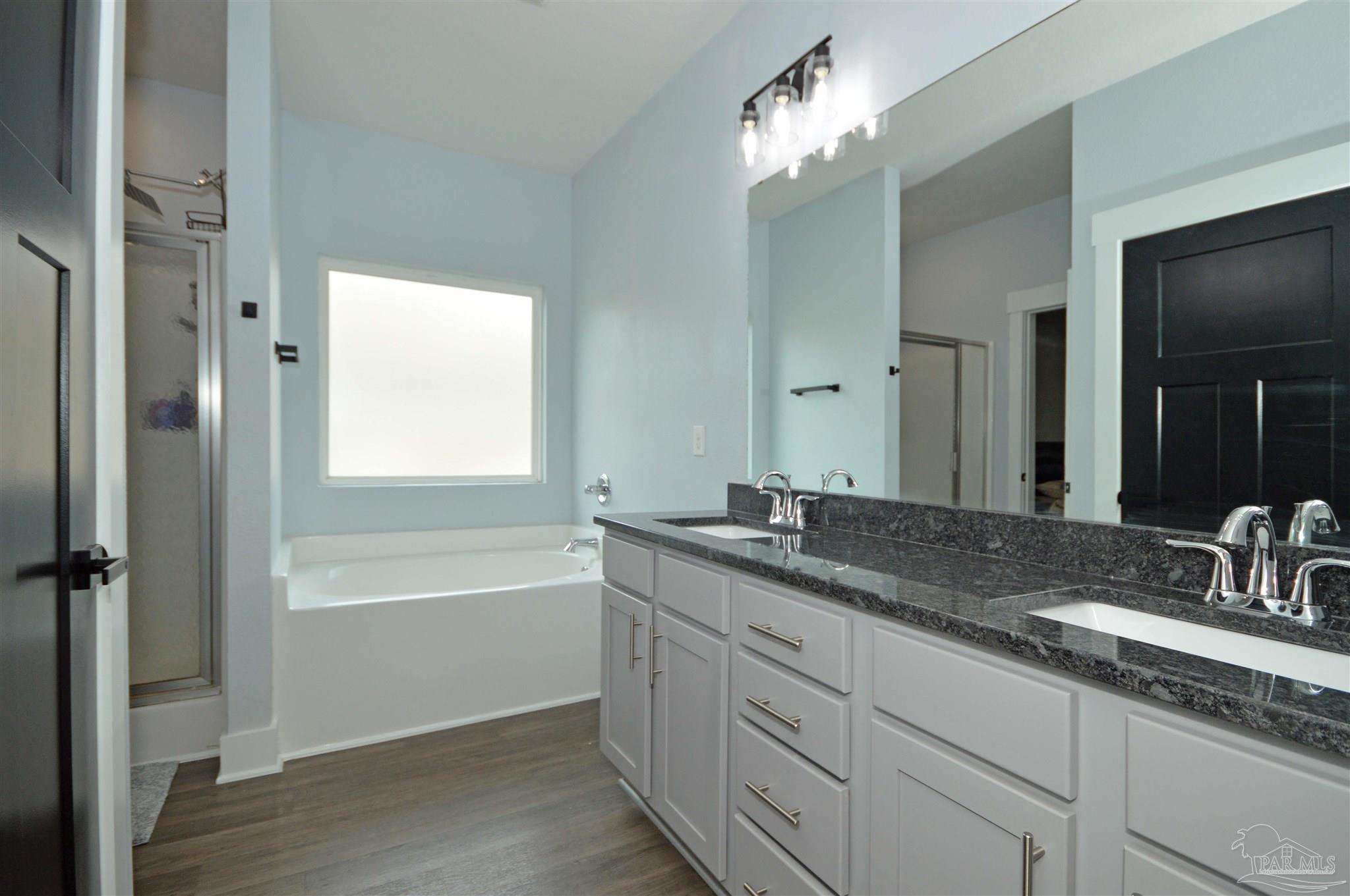 4453 Jude Way Pace, FL 32571 - Photo 33 of 41 a bathroom with a granite countertop double vanity sink a mirror and a bathtub