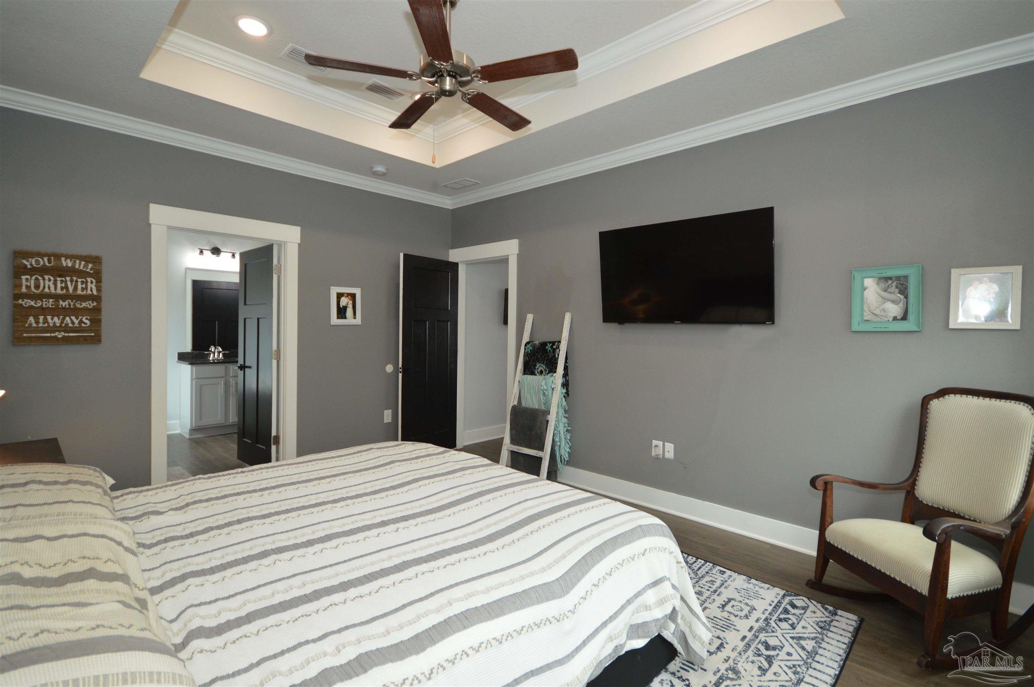 4453 Jude Way Pace, FL 32571 - Photo 34 of 41 a bedroom with a bed a flat screen tv and couches