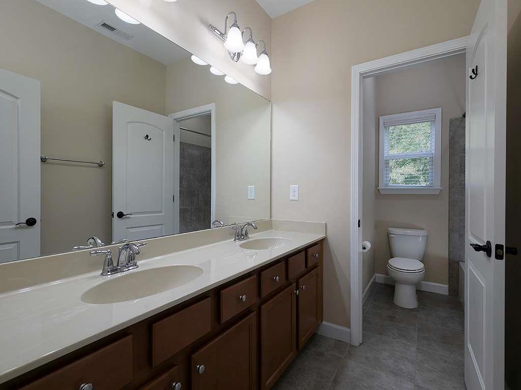 821 Tramore Road Acworth, GA 30102 - Photo 24 of 36 a bathroom with a granite countertop sink a toilet and a mirror