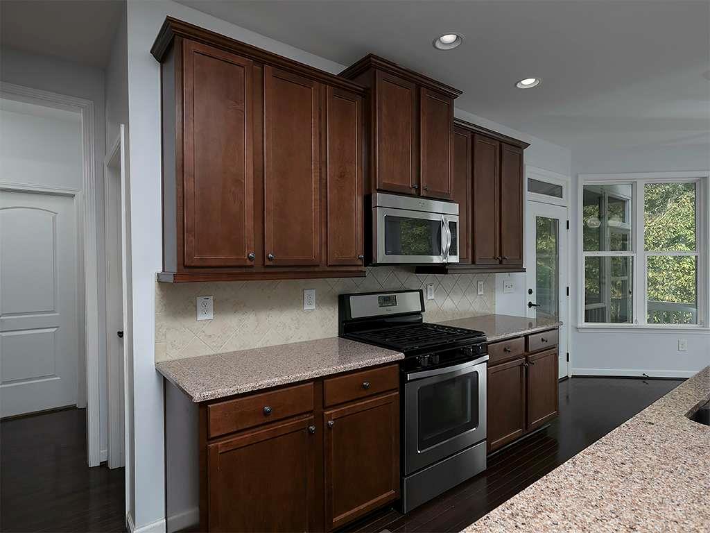 821 Tramore Road Acworth, GA 30102 - Photo 9 of 36 a kitchen with granite countertop wooden cabinets and stainless steel appliances