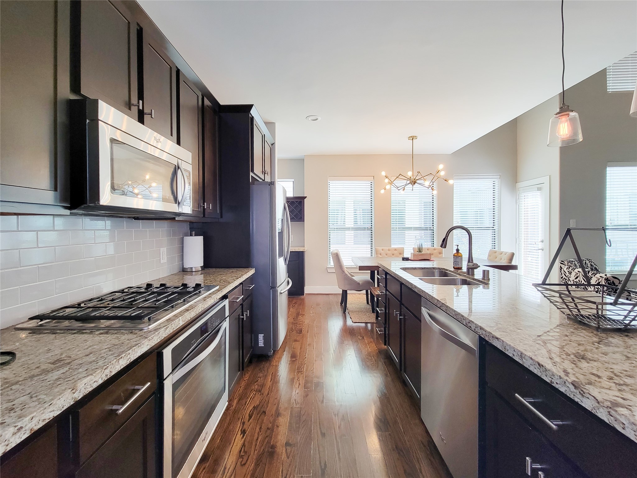 1424 Wilson Street Houston, TX 77019 - Photo 15 of 47 a kitchen with stainless steel appliances granite countertop a stove a sink dishwasher and a microwave oven with wooden floor