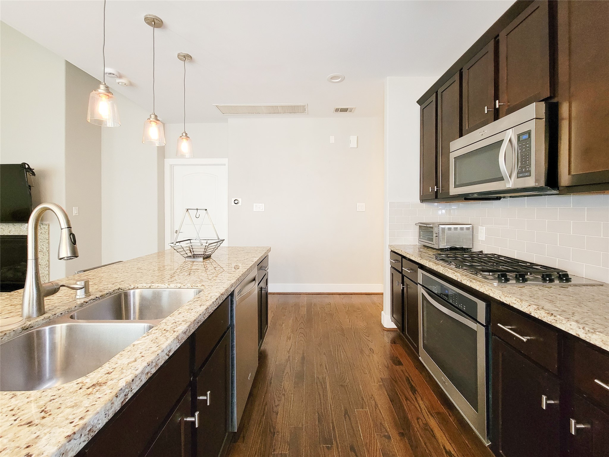1424 Wilson Street Houston, TX 77019 - Photo 19 of 47 a kitchen with stainless steel appliances granite countertop a sink a stove and a wooden floors