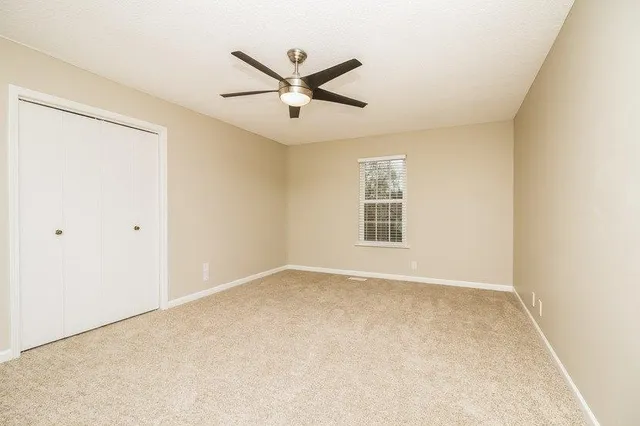 a view of a big room with wooden floor closet and windows in a room