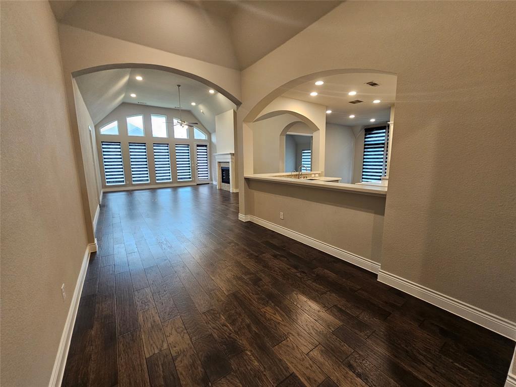 2065 Snapdragon Road Frisco, TX 75033 - Photo 13 of 39 Spacious interior featuring dark wood-finish flooring, vaulted ceilings, and large arched doorways