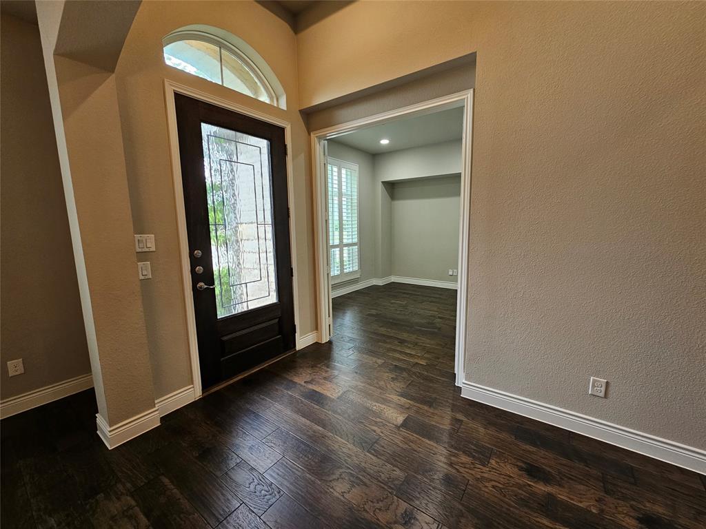 2065 Snapdragon Road Frisco, TX 75033 - Photo 16 of 39 Entryway featuring a dark wood-finish door with decorative glass, an arched transom window, and dark wood-finish flooring