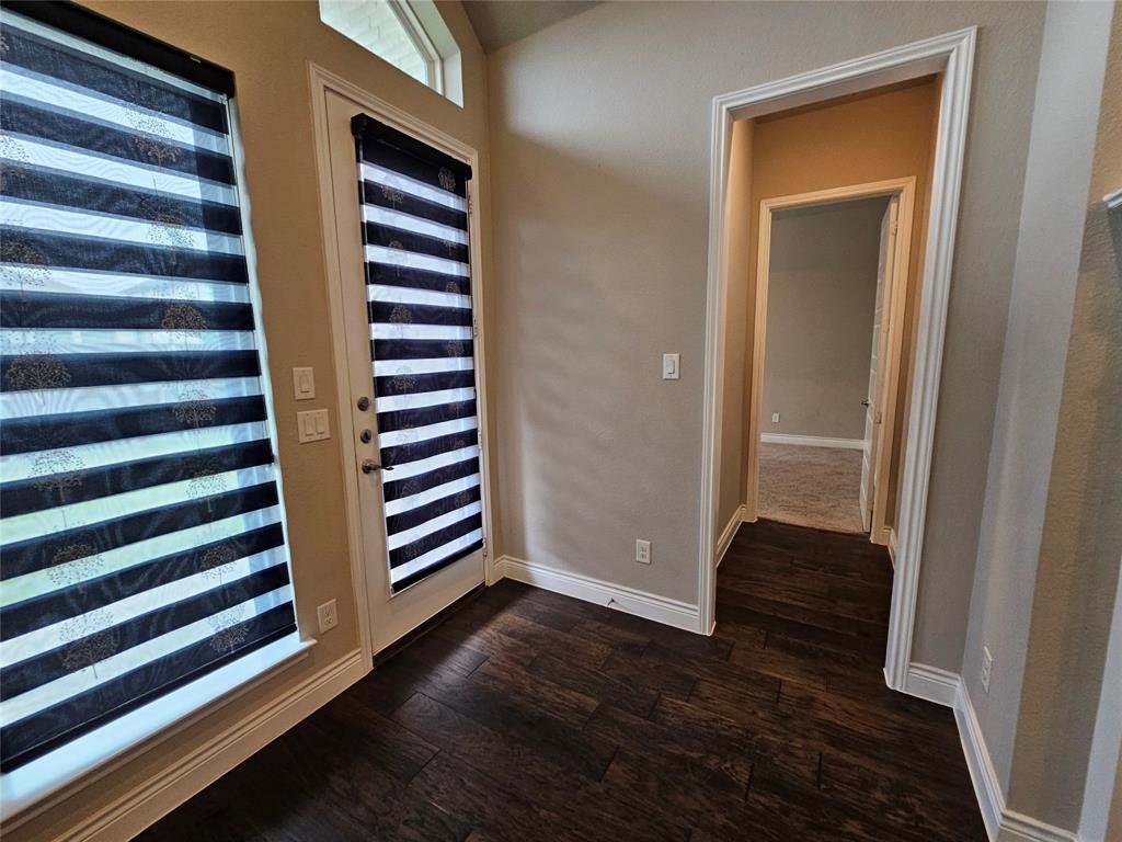2065 Snapdragon Road Frisco, TX 75033 - Photo 18 of 39 Dark wood-finish flooring extending into a hallway with neutral-toned walls