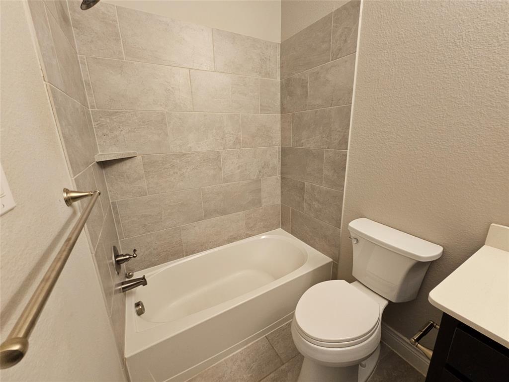 2065 Snapdragon Road Frisco, TX 75033 - Photo 23 of 39 Shower-over-tub combination with light gray rectangular tile surround extending to the ceiling