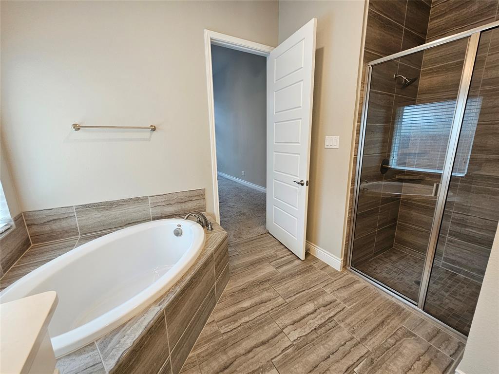 2065 Snapdragon Road Frisco, TX 75033 - Photo 28 of 39 Spacious bathroom featuring a built-in soaking tub, a separate glass-enclosed shower with a built-in bench, and large format tile flooring