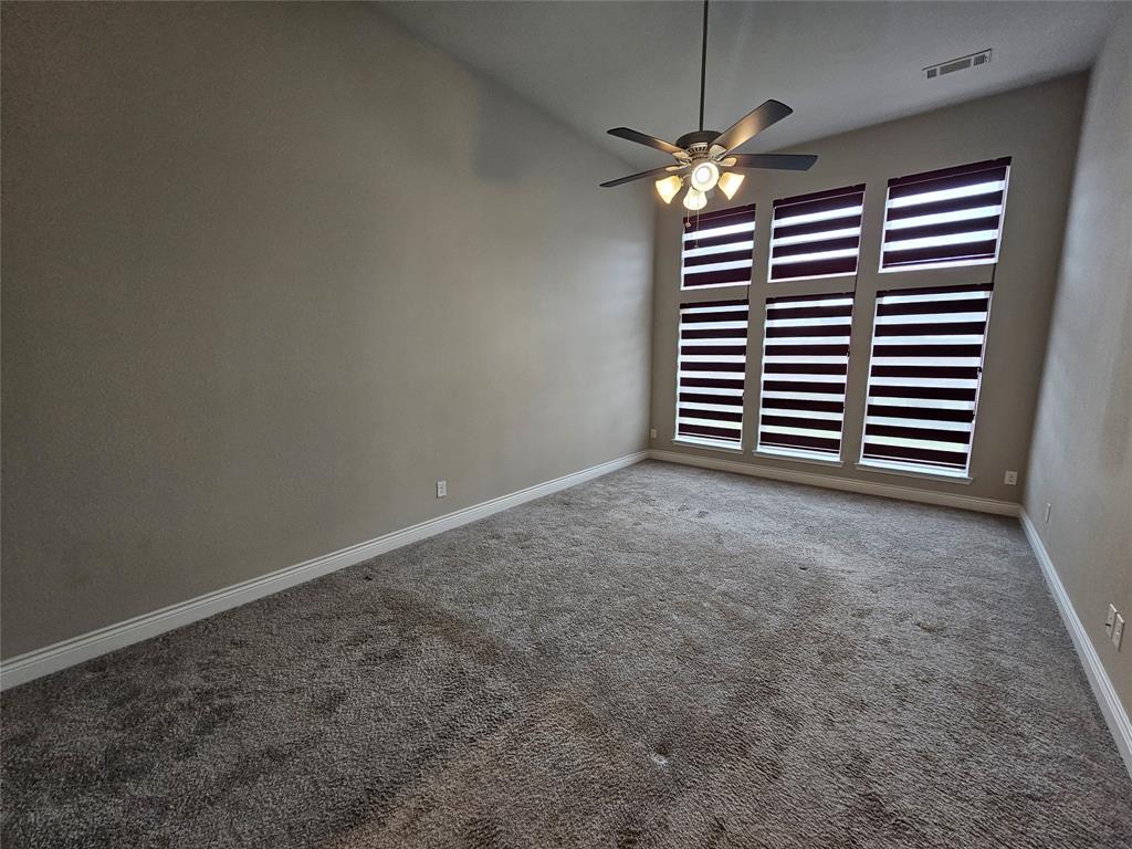 2065 Snapdragon Road Frisco, TX 75033 - Photo 29 of 39 Spacious room featuring vaulted ceilings, a contemporary ceiling fan, and six vertical windows with layered blinds