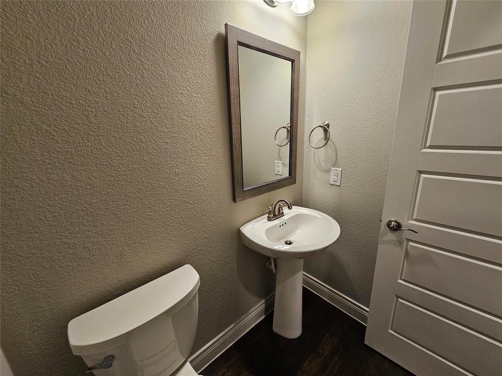 2065 Snapdragon Road Frisco, TX 75033 - Photo 35 of 39 Pedestal sink with brushed nickel faucet, framed mirror, and coordinating wall sconce lighting