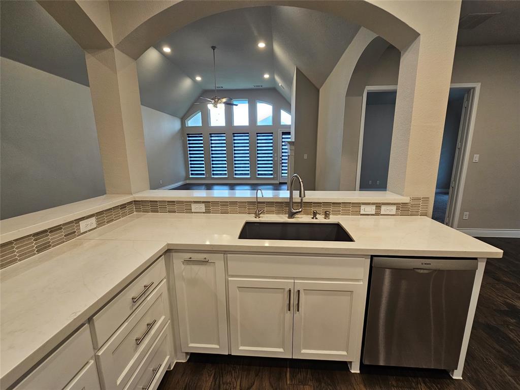 2065 Snapdragon Road Frisco, TX 75033 - Photo 5 of 39 Kitchen with white cabinetry, light-toned countertops, and a mosaic tile backsplash