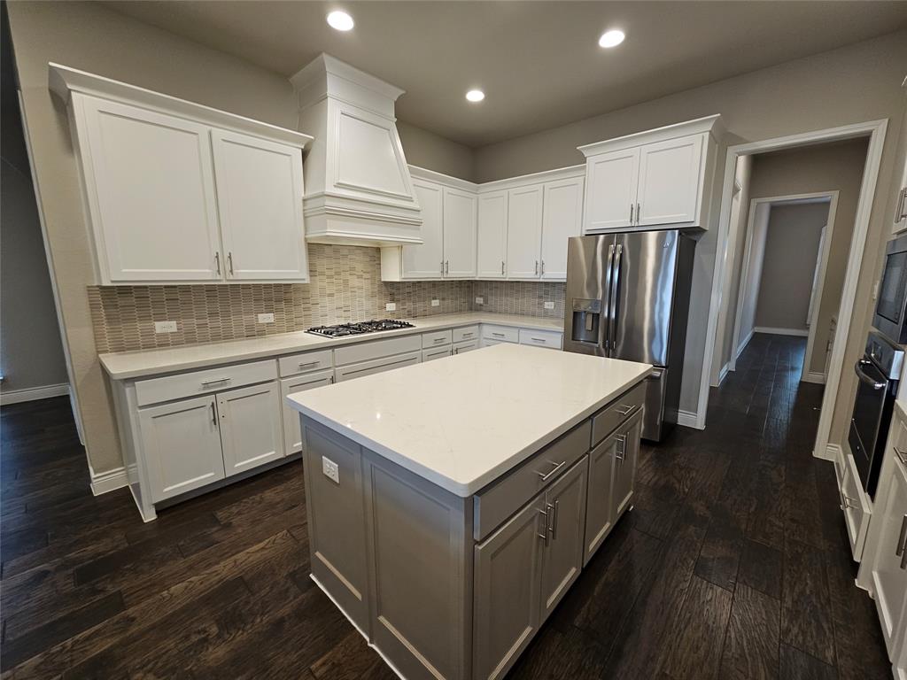 2065 Snapdragon Road Frisco, TX 75033 - Photo 6 of 39 Spacious room featuring wood-finish flooring, an arched doorway, and a contemporary linear chandelier with cylindrical shades