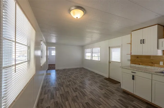 a view of a kitchen with wooden floor and windows