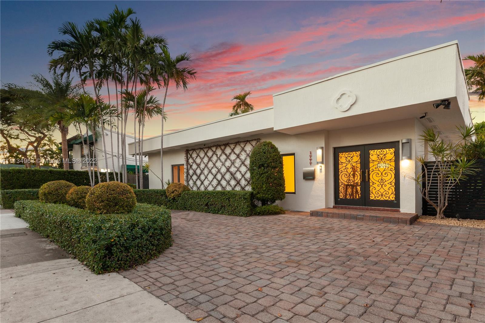 1777 Daytonia Road Miami Beach, FL 33141 - Photo 1 of 36 a front view of a house with garden and patio