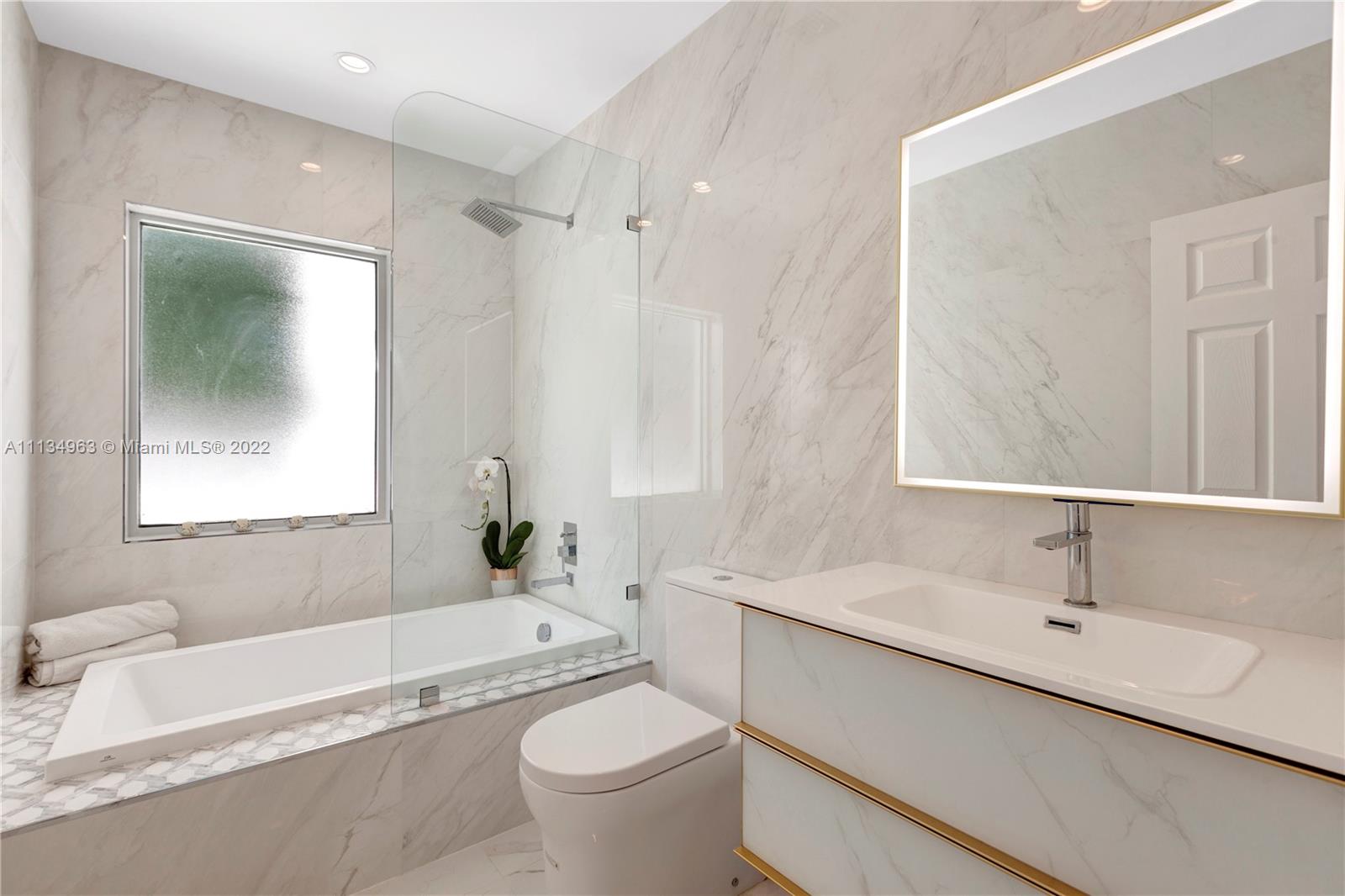 1777 Daytonia Road Miami Beach, FL 33141 - Photo 21 of 36 a bathroom with a granite countertop sink mirror bathtub and toilet