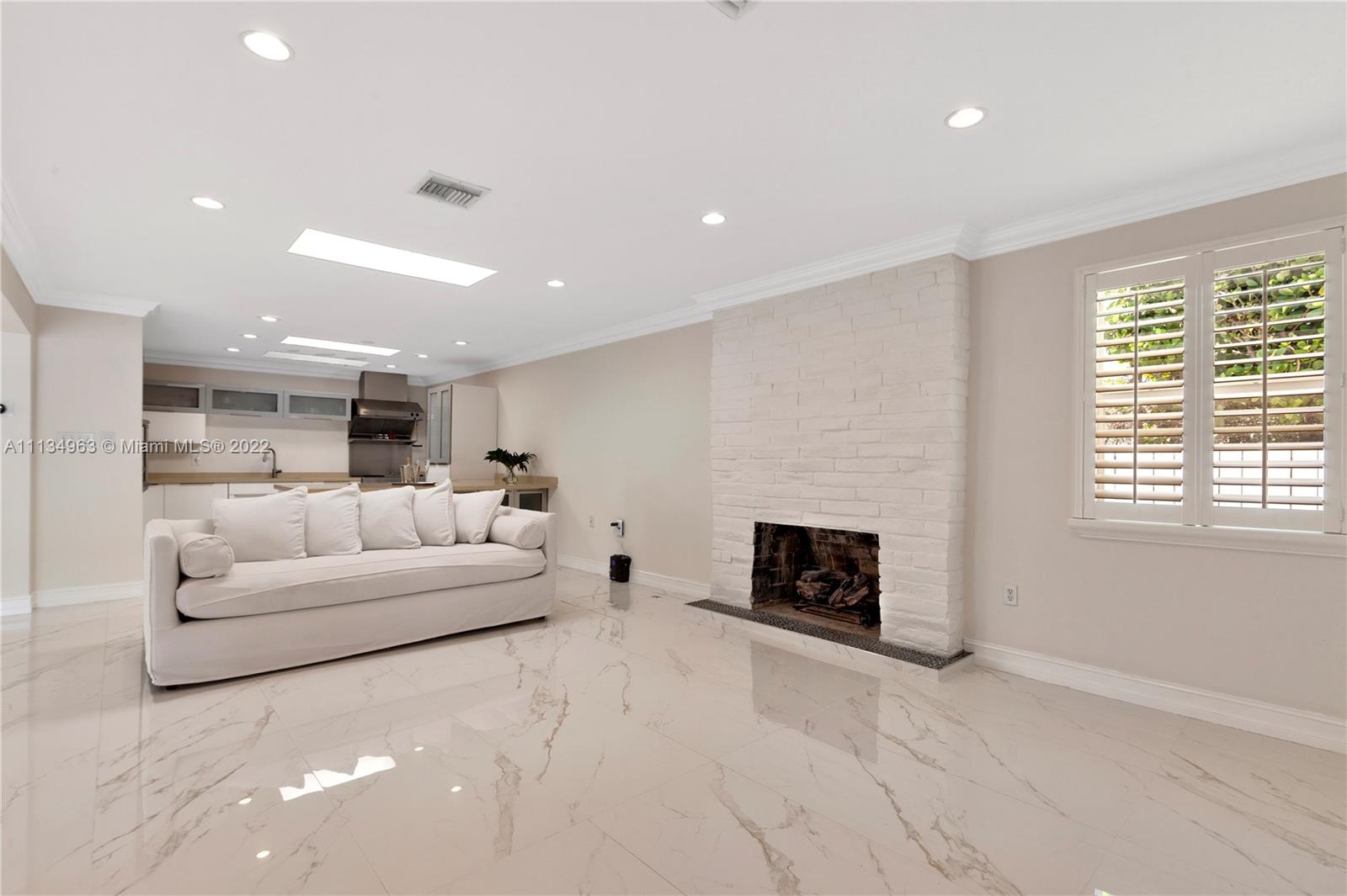 1777 Daytonia Road Miami Beach, FL 33141 - Photo 6 of 36 a living room with furniture white fireplace and a window