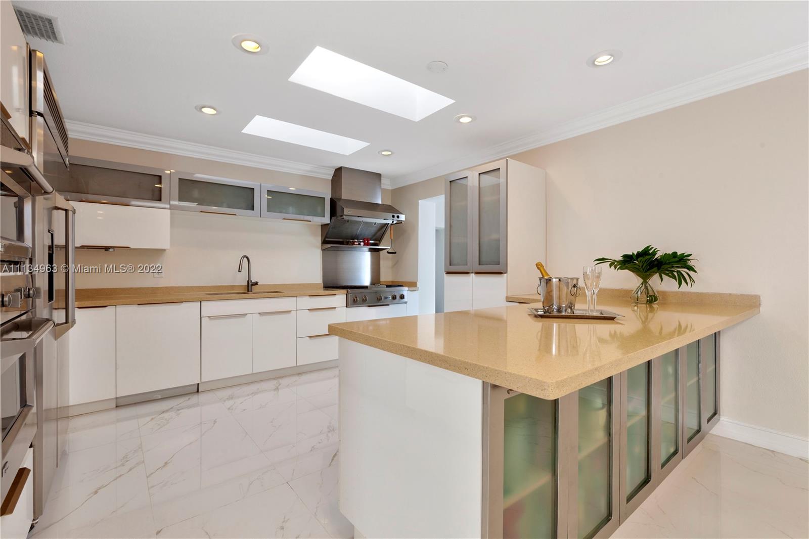 1777 Daytonia Road Miami Beach, FL 33141 - Photo 8 of 36 a kitchen with sink cabinets and microwave