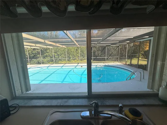 a view of a room with wooden floor and a floor to ceiling window