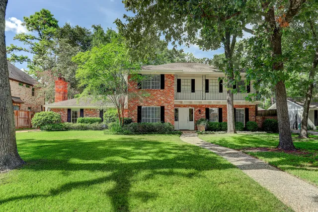 a view of a big house with a big yard and large trees