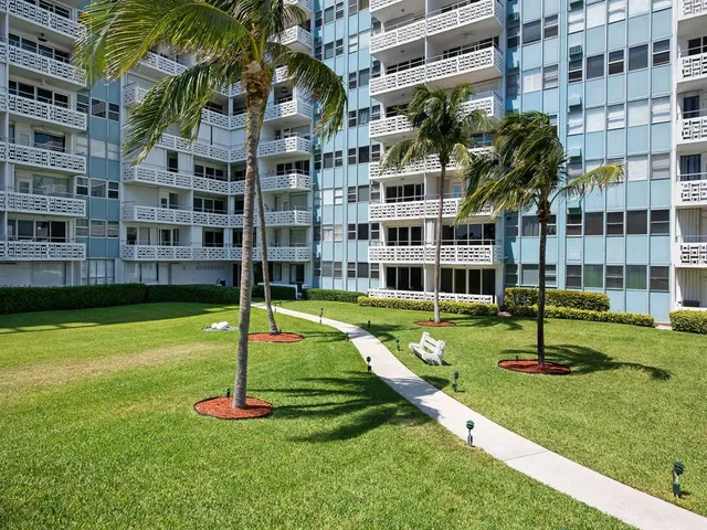 a garden with tall buildings in the background