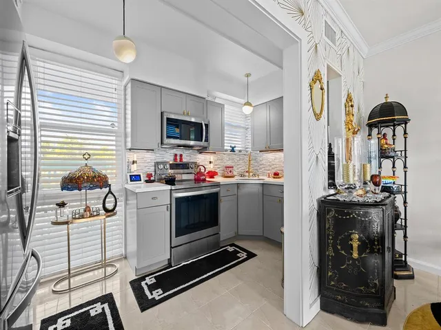 a kitchen with a sink appliances cabinets and furniture