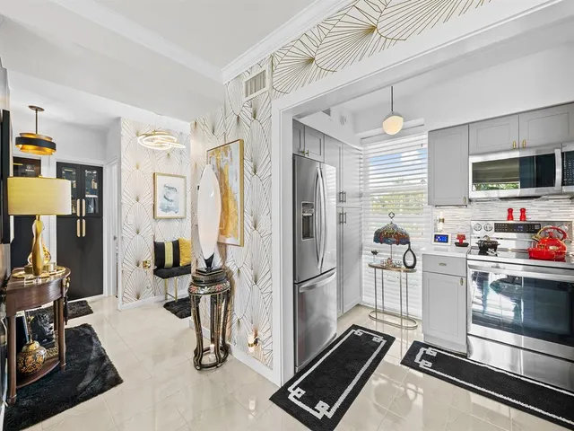 a kitchen with stainless steel appliances kitchen island granite countertop a refrigerator and a stove top oven