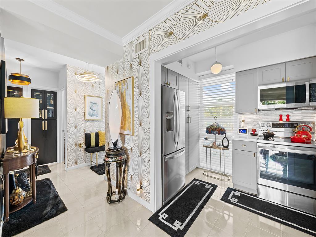 1900 South Ocean Drive, Unit 210 Fort Lauderdale, FL 33316 - Photo 7 of 31 a kitchen with stainless steel appliances kitchen island granite countertop a refrigerator and a stove top oven