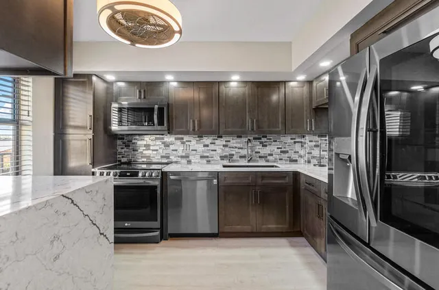 a kitchen with stainless steel appliances granite countertop a stove and a refrigerator
