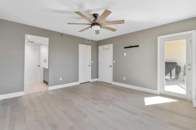 a view of an empty room with a ceiling fan