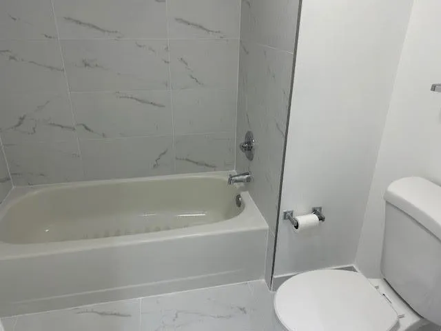 a white bath tub sitting next to a toilet