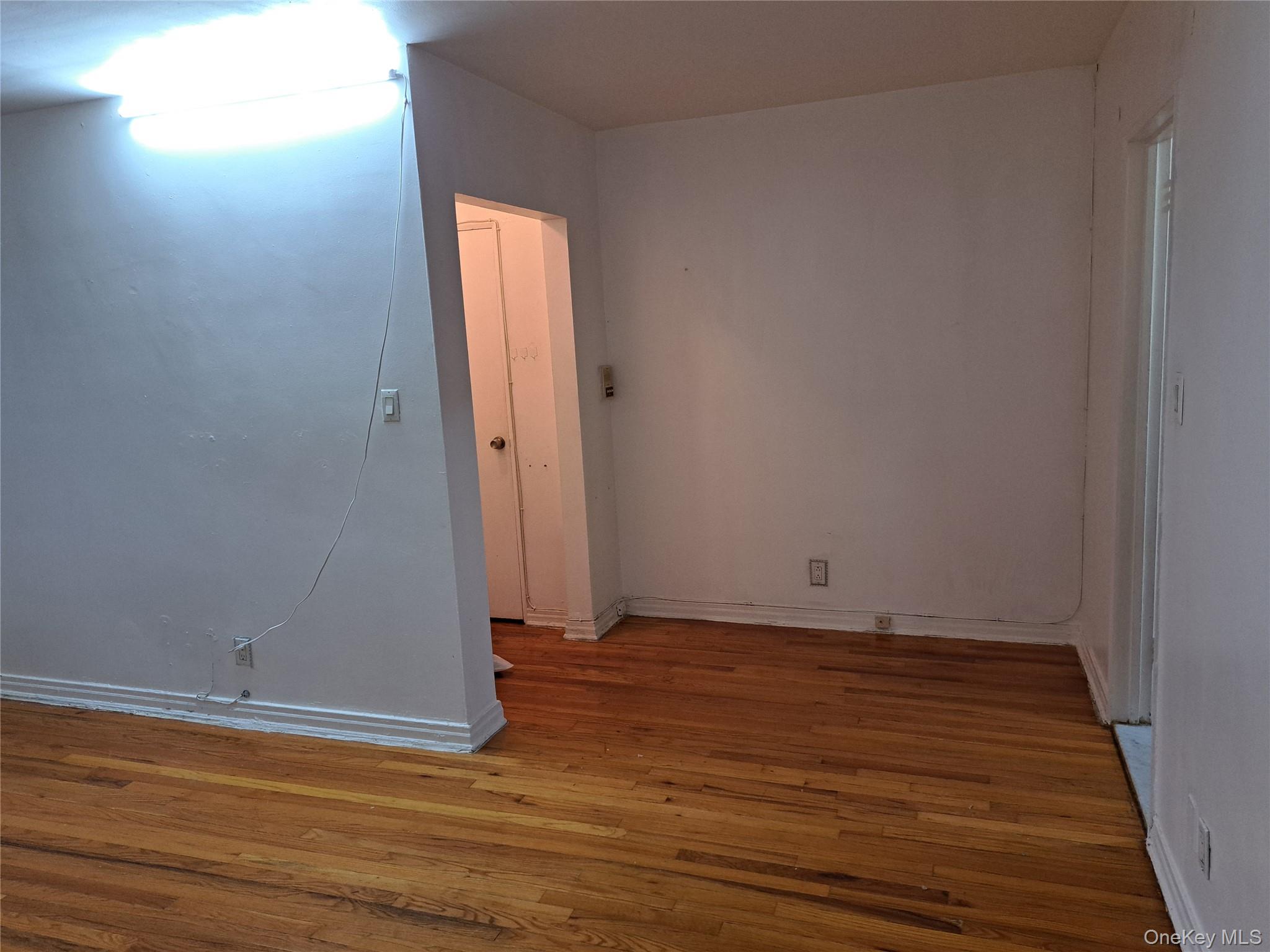 20206 Rocky Hill Road, Unit C1 Queens, NY 11361 - Photo 13 of 17 a view of an empty room with wooden floor and a window